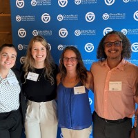 PA Alumni group take picture together in front of GVSU Alumni Association sign